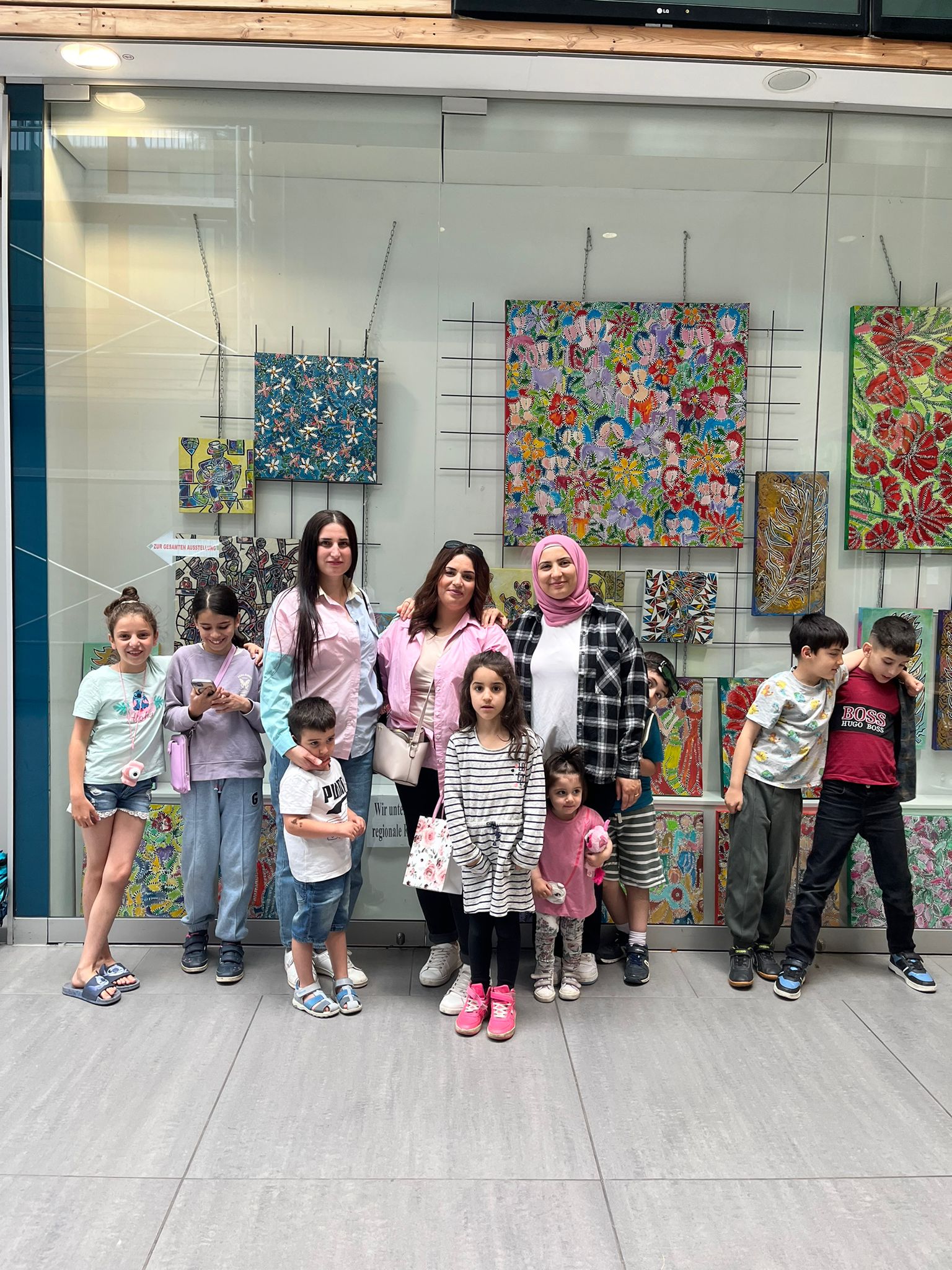 Kinder und Erwachsene vor einem Fenster mit kreativen Arbeiten bei Bilmatî